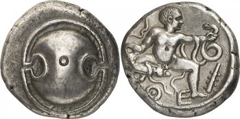 Estáter de prata cunhado na pólis grega de Tebas. Apresenta o escudo da região da Beócia e Hércules ainda bebê lutando com serpentes.